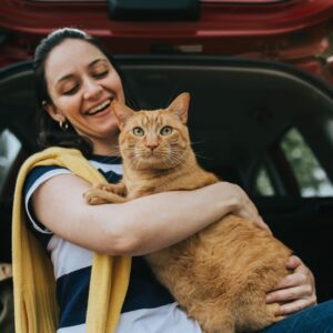 cat and owner hugging in car