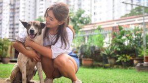 young woman hugging happy dog