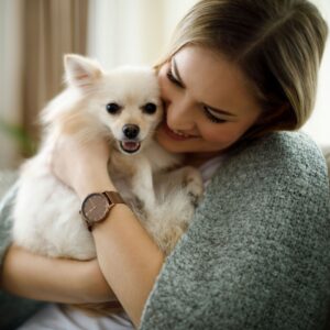a woman hugging a small dog