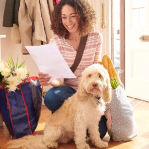 person reading mail while petting dog