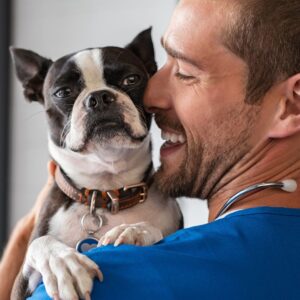 smiling vet holding dog in arms