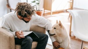 A person sitting in a chair and petting a dog