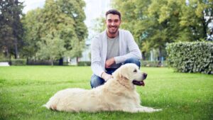 Person kneeling by a dog outside